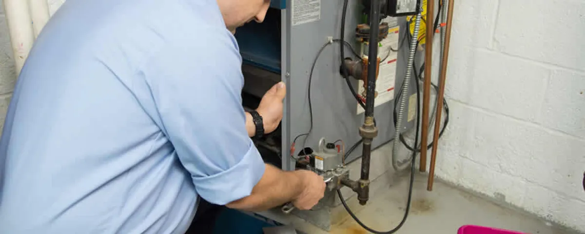 Furnace repair technician inspecting and servicing a home heating system in Concord, MA