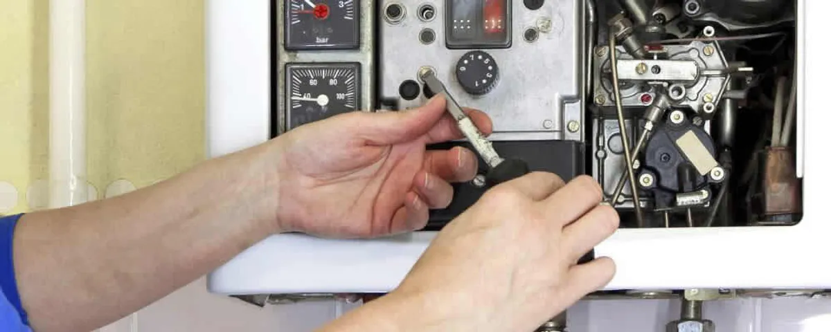 Heating repair technician adjusting boiler controls and components in Concord, MA